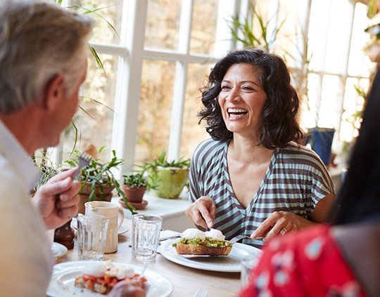 People laugh over brunch