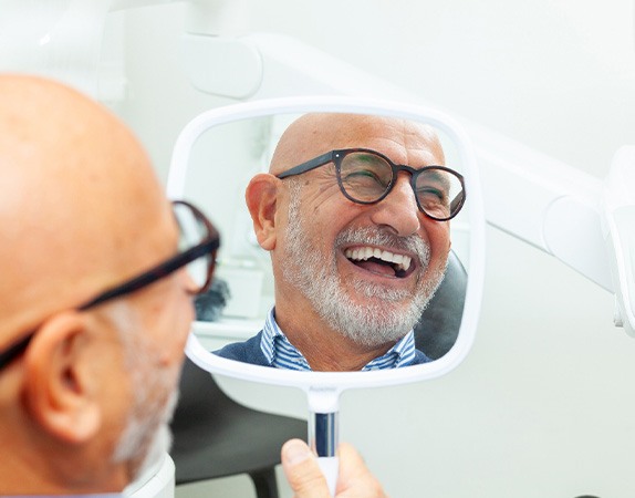 A man smiling at his new dental implants