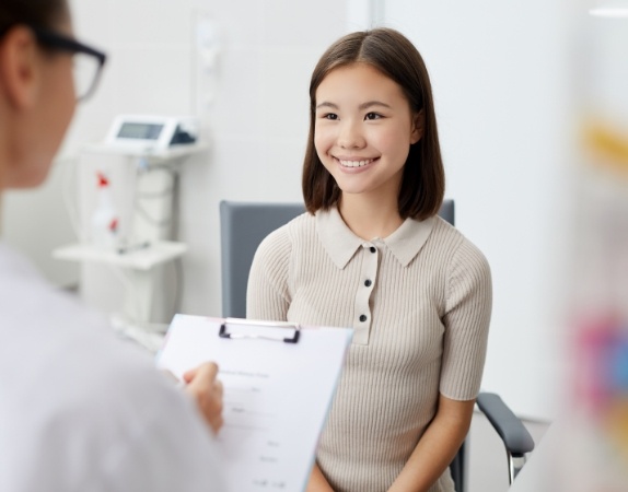 Woman smiling while talking to her dentist