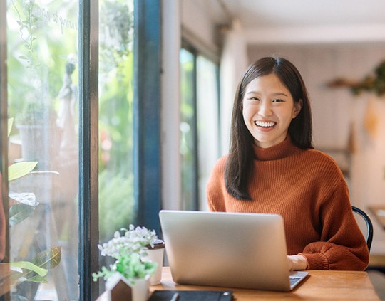 Charlotte patient smiling while working on laptop