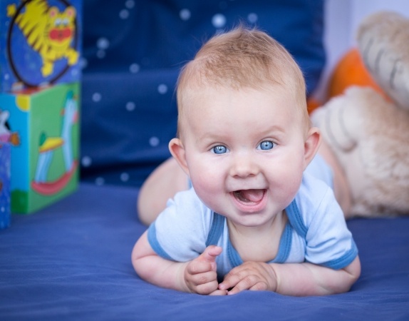 Smiling baby laying on their stomach