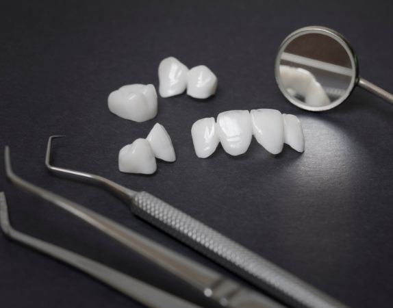 Several white dental crowns and veneers on table