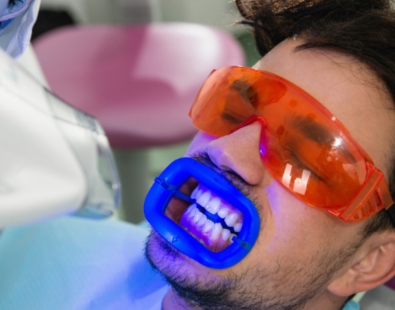 Man receiving professional teeth whitening in dental office