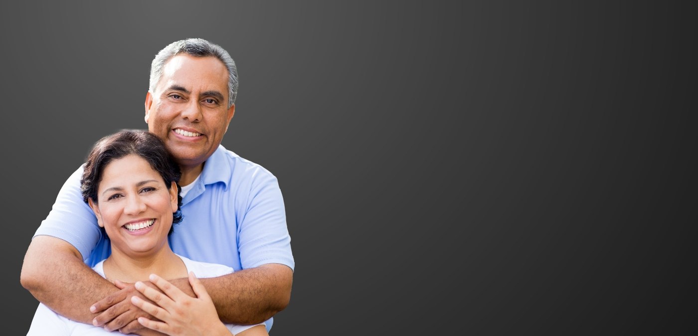 Man and woman hugging and smiling with dental implants in Charlotte