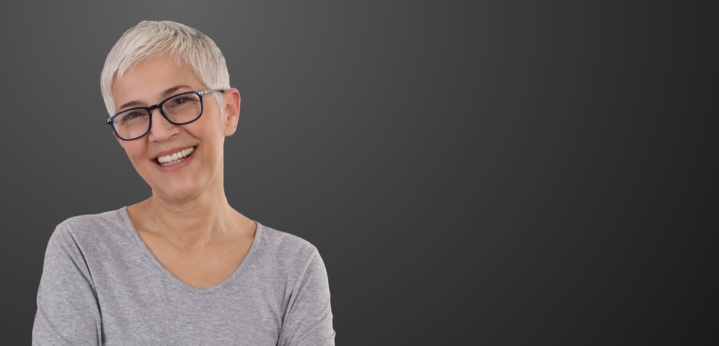 Smiling older woman in gray blouse