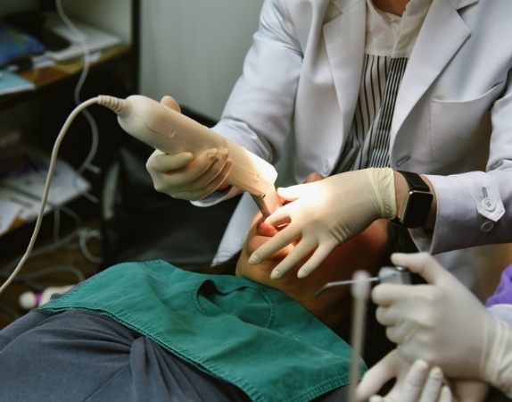 Dentist taking digital impressions of a patients teeth
