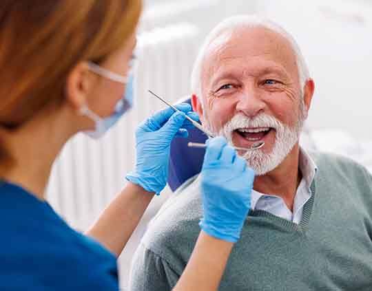 Man smiles at dentist