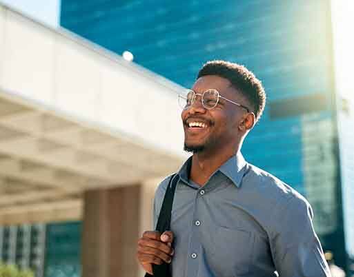 Man with glasses smiling while walking outside