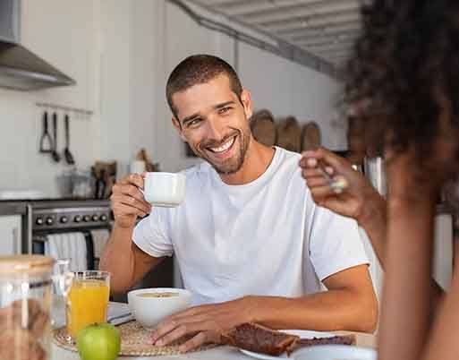 Man smiling while enjoying coffee at home