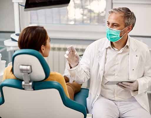 Smiling dentist and patient talking in treatment room