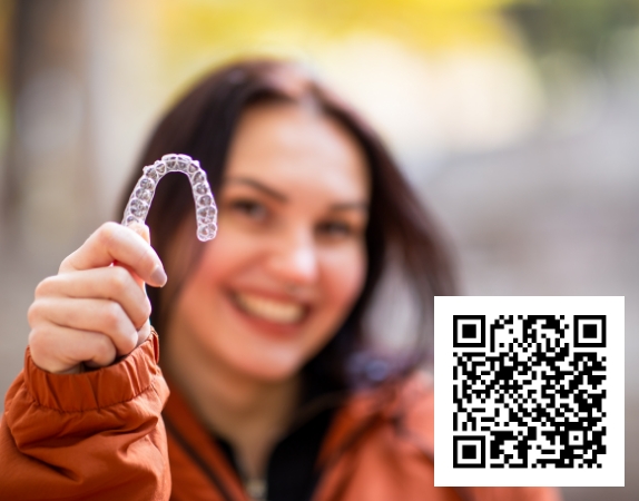Hand holding an Invisalign clear aligner