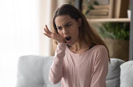 Patient in McAlpine holding mouth in pain