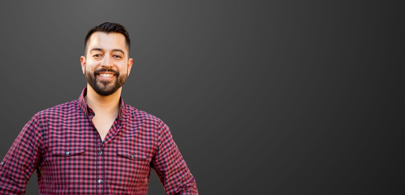 Smiling man in red and black plaid shirt