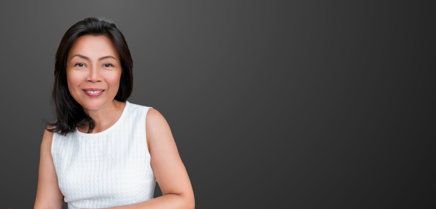 Woman in white blouse smiling after restorative dentistry in Charlotte