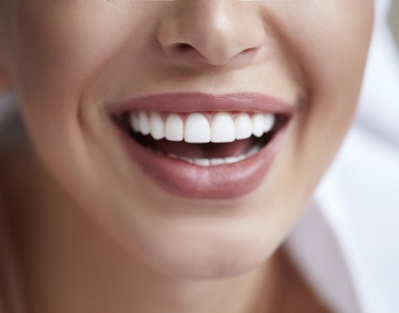 Close up of a person smiling with straight white teeth