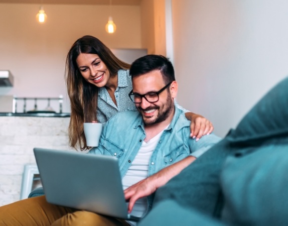 Man and woman looking on laptop for dentist reviews in Charlotte