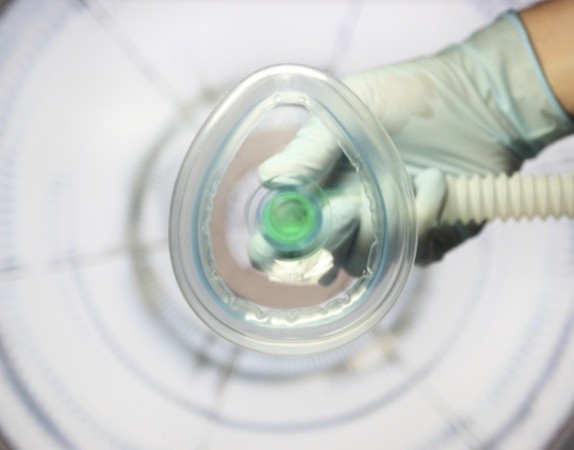 Dental professional holding nitrous oxide mask above the camera