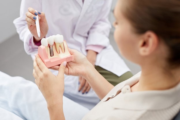 woman at dentist holding dental implants 