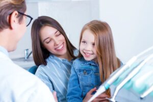 Mom and daughter talking to friendly dentist