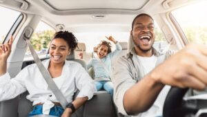 a family laughing and singing in the car while driving to the dental office