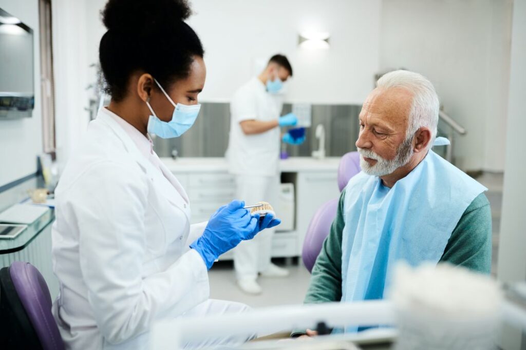 A dentist showing a patient a denture